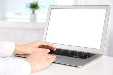 Photo of Woman working with modern laptop indoors, closeup. Space for design