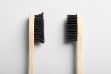 Old and new bamboo toothbrushes on white background, flat lay