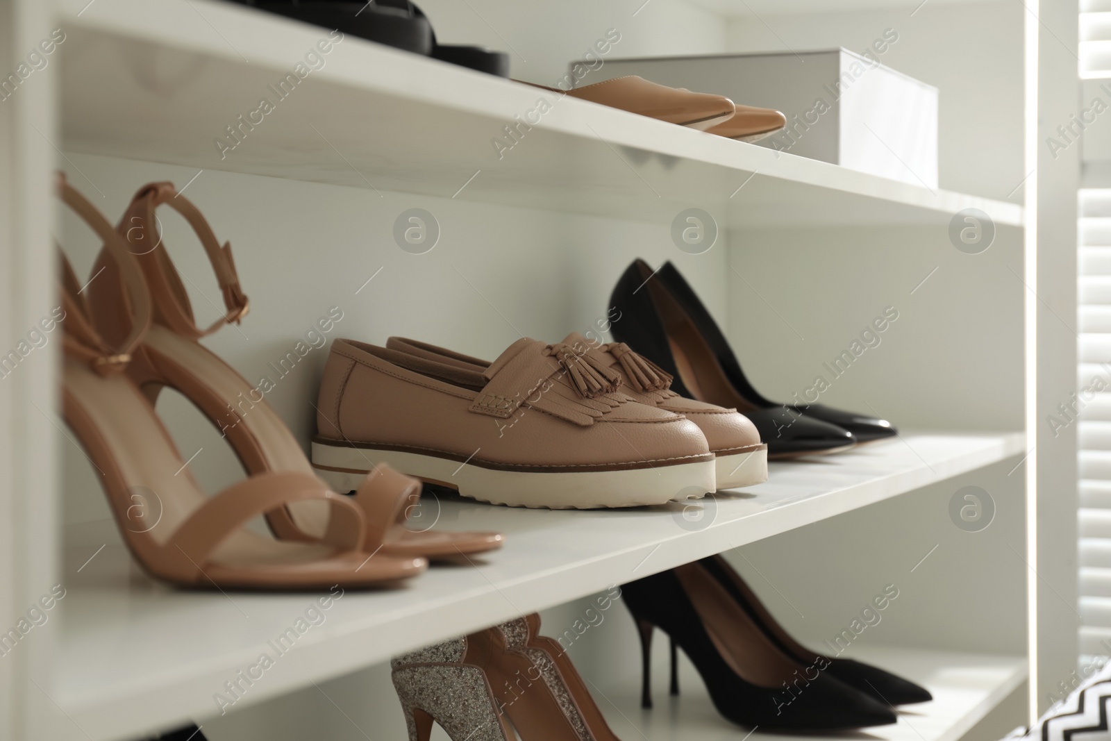 Photo of Storage rack with stylish women's shoes indoors