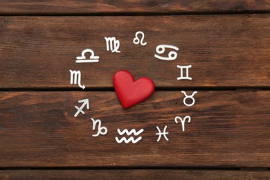 Zodiac signs and red heart on wooden background, flat lay