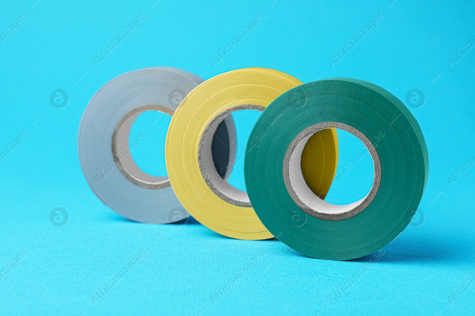 Photo of Colorful insulating tapes on light blue background