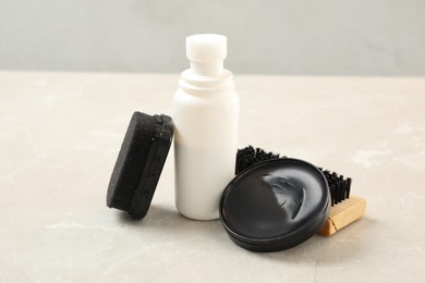 Photo of Shoe care accessories on light marble table, closeup