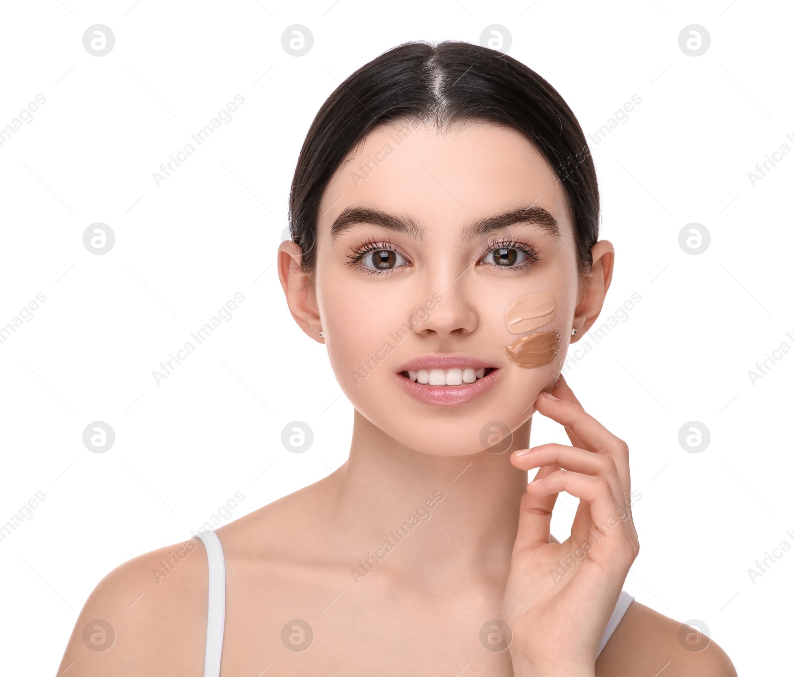 Photo of Teenage girl with swatches of foundation on face against white background