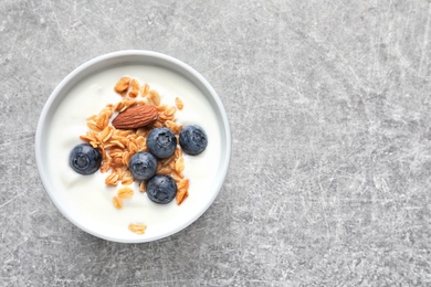 Photo of Bowl with yogurt, berries and granola on table, top view