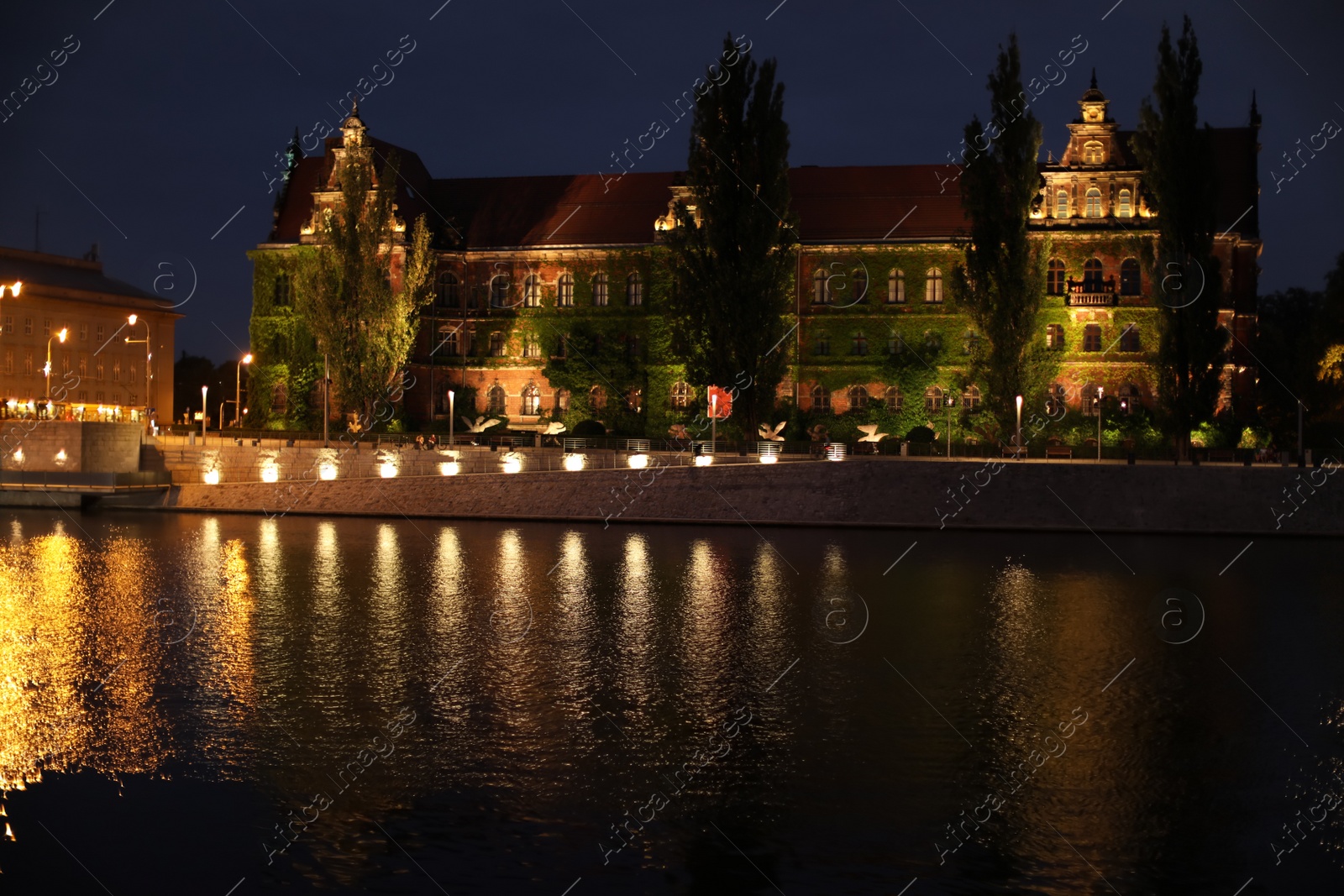 Photo of Beautiful view of illuminated city near river at night