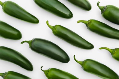 Many green hot chili peppers on white background, flat lay