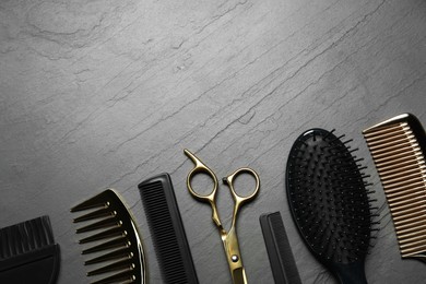 Photo of Hairdressing tools on grey textured background, flat lay. Space for text