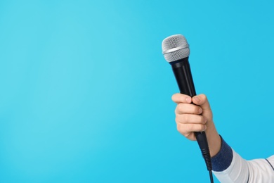 Photo of Child holding microphone on color background, closeup of hand. Space for text