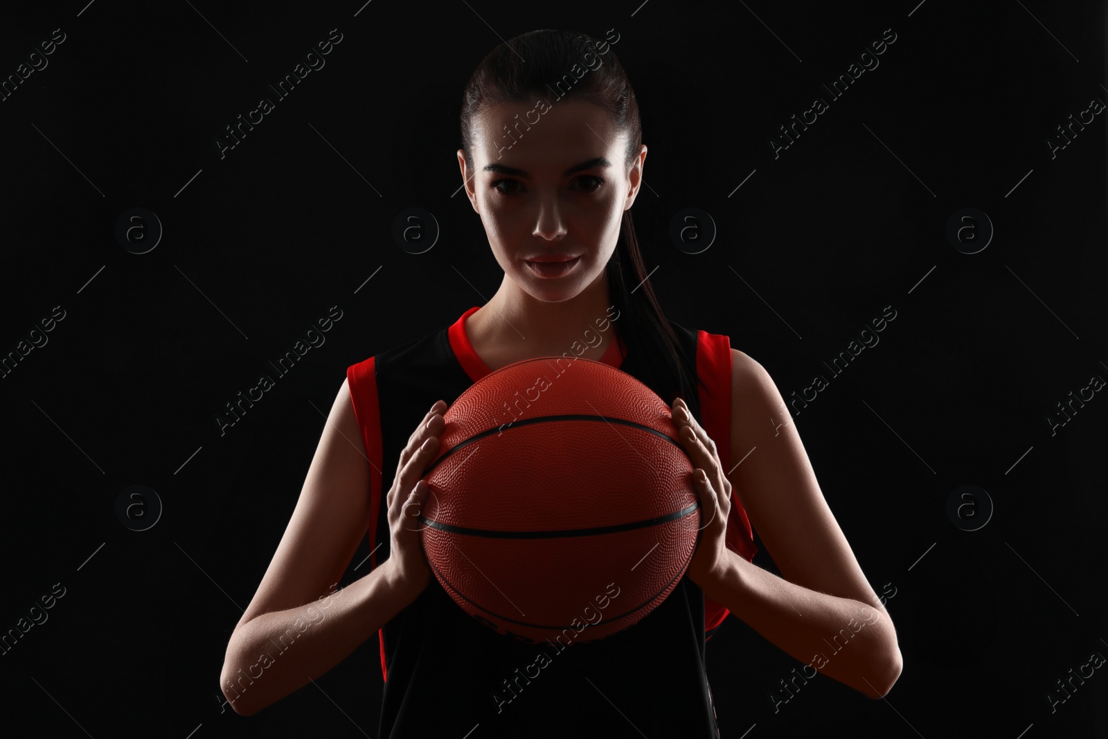 Photo of Basketball player with ball on black background