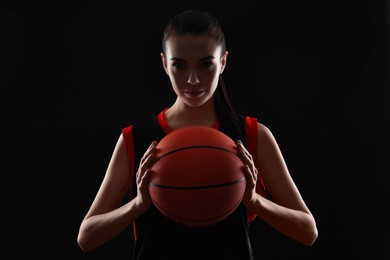 Basketball player with ball on black background