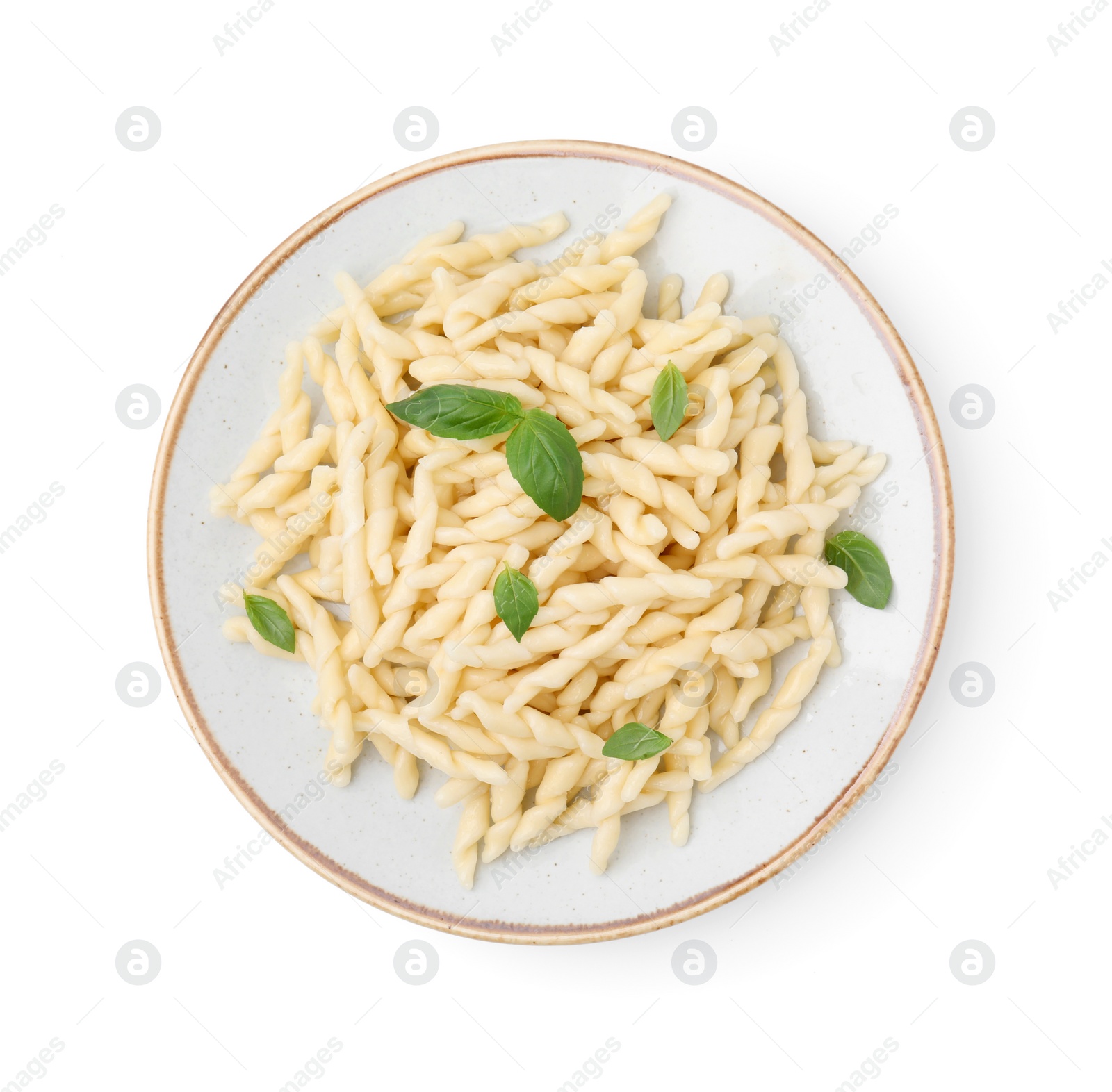Photo of Plate of delicious trofie pasta with basil leaves isolated on white, top view