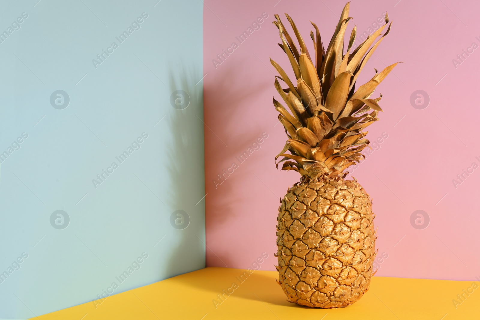 Photo of Golden pineapple on color background, space for text. Creative concept