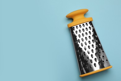 Photo of Modern grater on light blue background, top view. Space for text