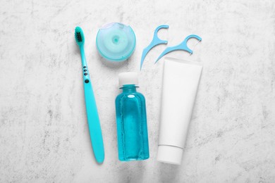 Photo of Flat lay composition with dental floss and different teeth care products on light grey textured table