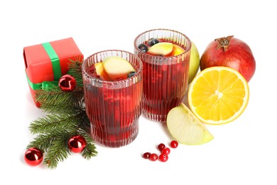 Photo of Aromatic Sangria drink in glasses, ingredients and Christmas decor isolated on white