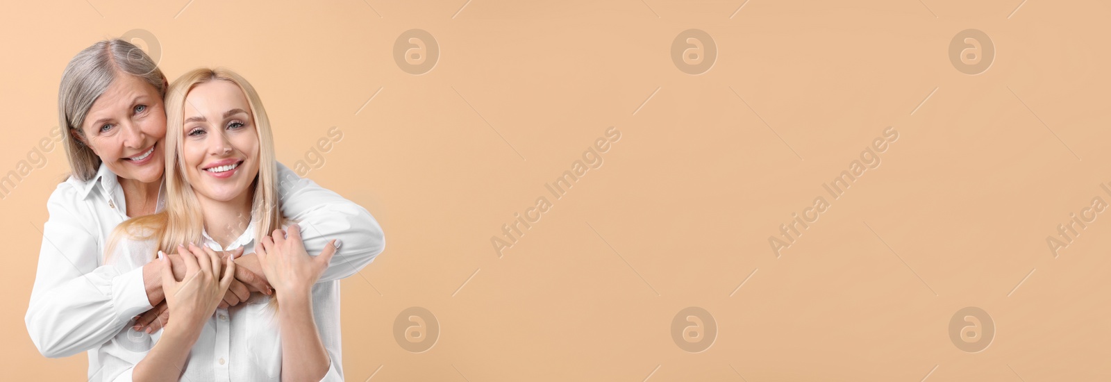Image of Happy mother and daughter on beige background, space for text. Banner design