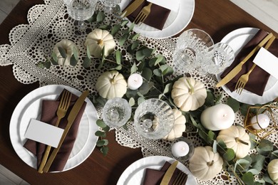 Photo of Beautiful autumn table setting. Plates, cutlery, glasses, blank cards and floral decor, flat lay