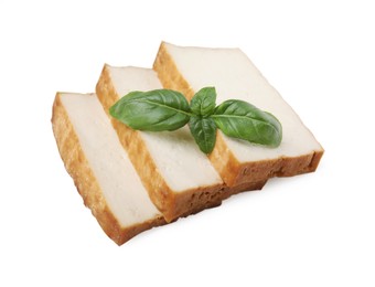 Photo of Slices of delicious smoked tofu and basil isolated on white