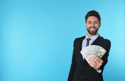 Photo of Portrait of happy young businessman with money on color background. Space for text