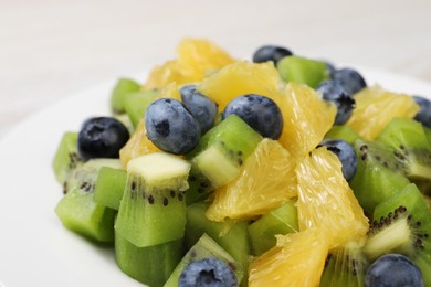 Photo of Fresh tasty fruit salad on plate, closeup