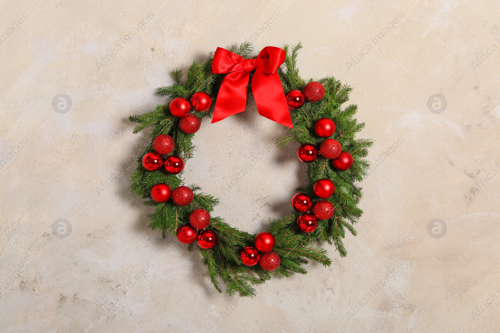 Photo of Beautiful Christmas wreath with festive decor on light wall