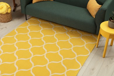 Photo of Yellow carpet with geometric pattern on wooden floor in living room