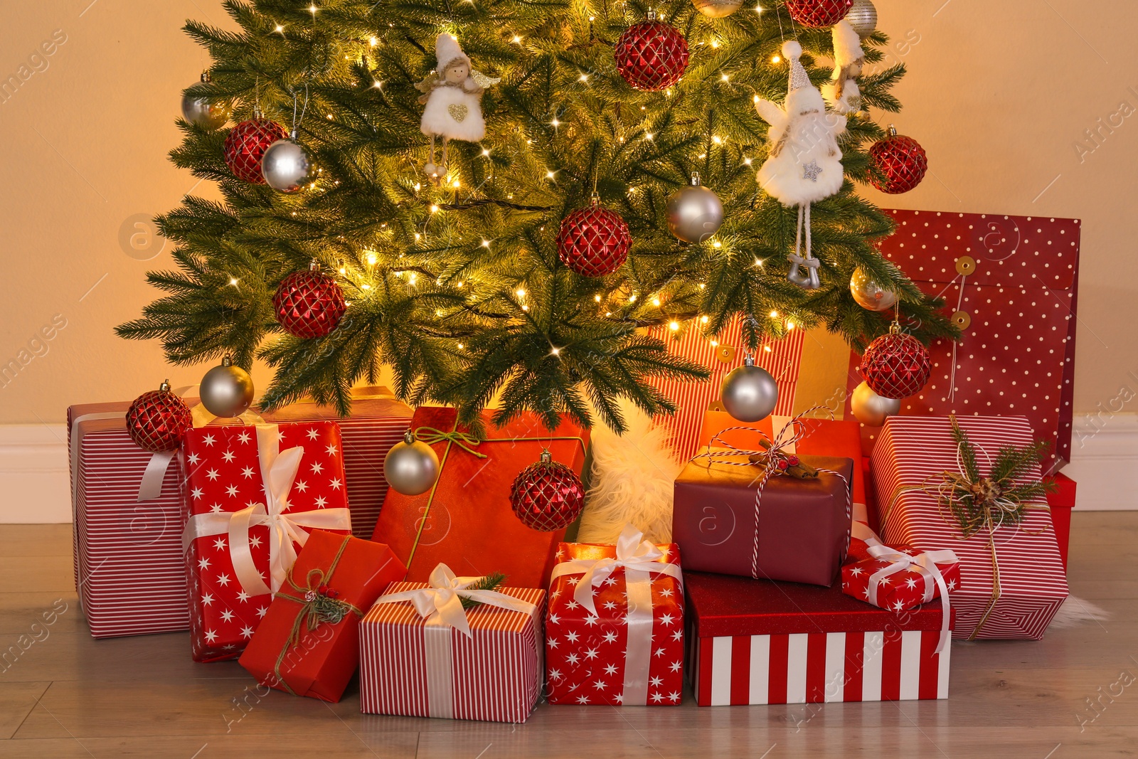 Photo of Pile of gift boxes near Christmas tree indoors