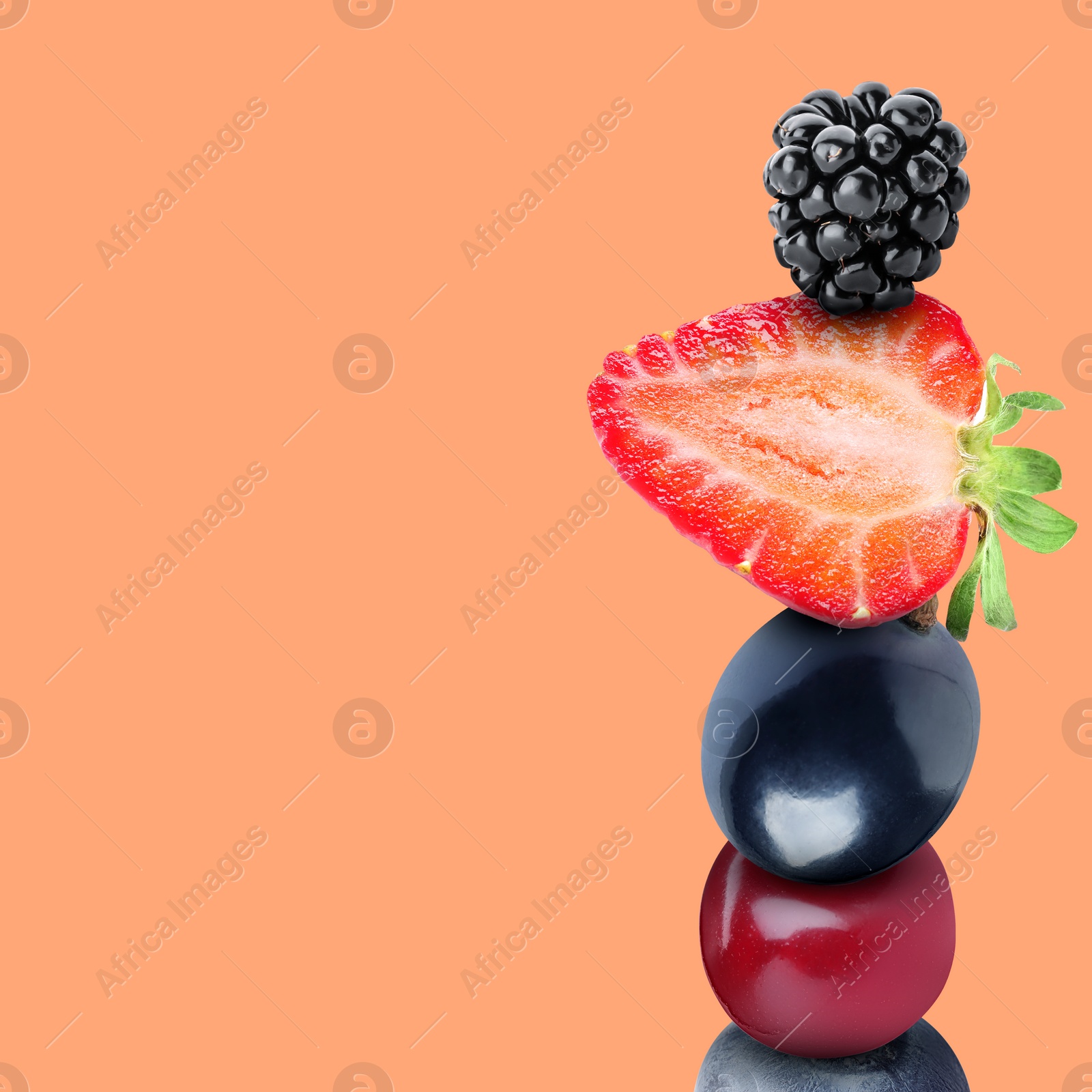 Image of Stack of different fresh tasty berries on light coral background, space for text