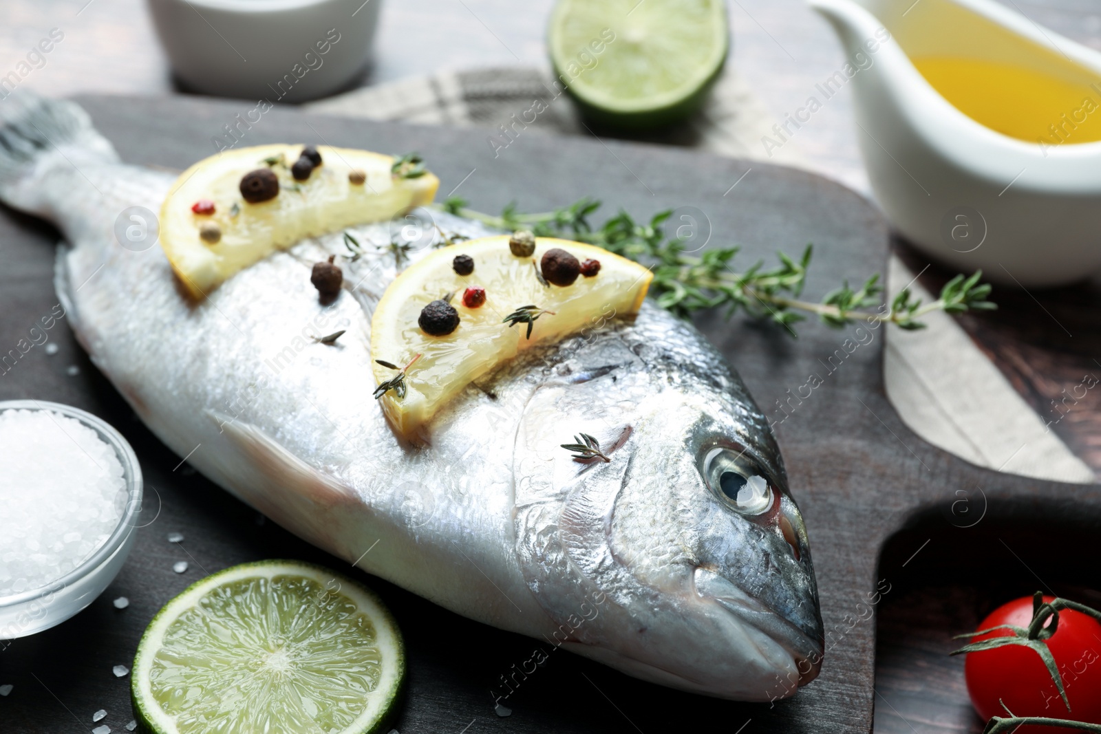 Photo of Fresh dorado fish and ingredients on wooden board, closeup