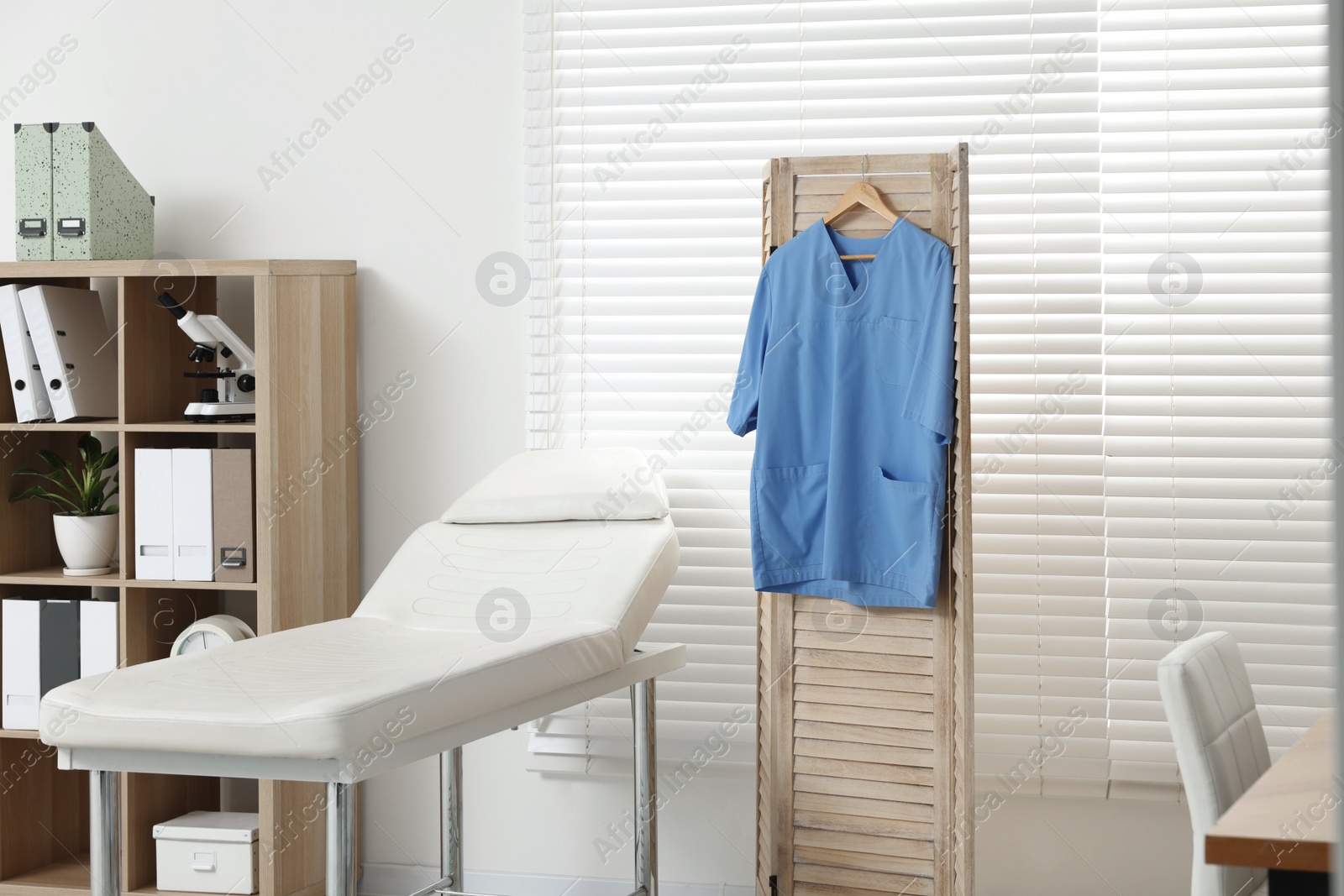 Photo of Modern medical office with doctor's workplace and examination table in clinic