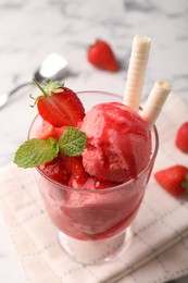 Photo of Tasty strawberry ice cream with fresh berries and wafer rolls in glass dessert bowl on table, closeup