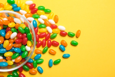 Bowl of jelly beans on color background, top view. Space for text