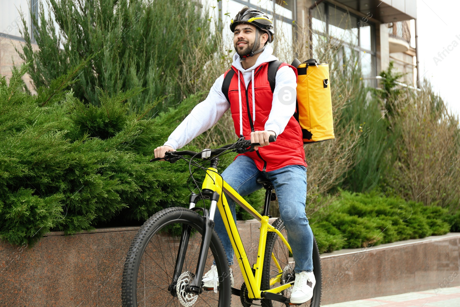 Photo of Courier with thermo bag riding bicycle outdoors. Food delivery service