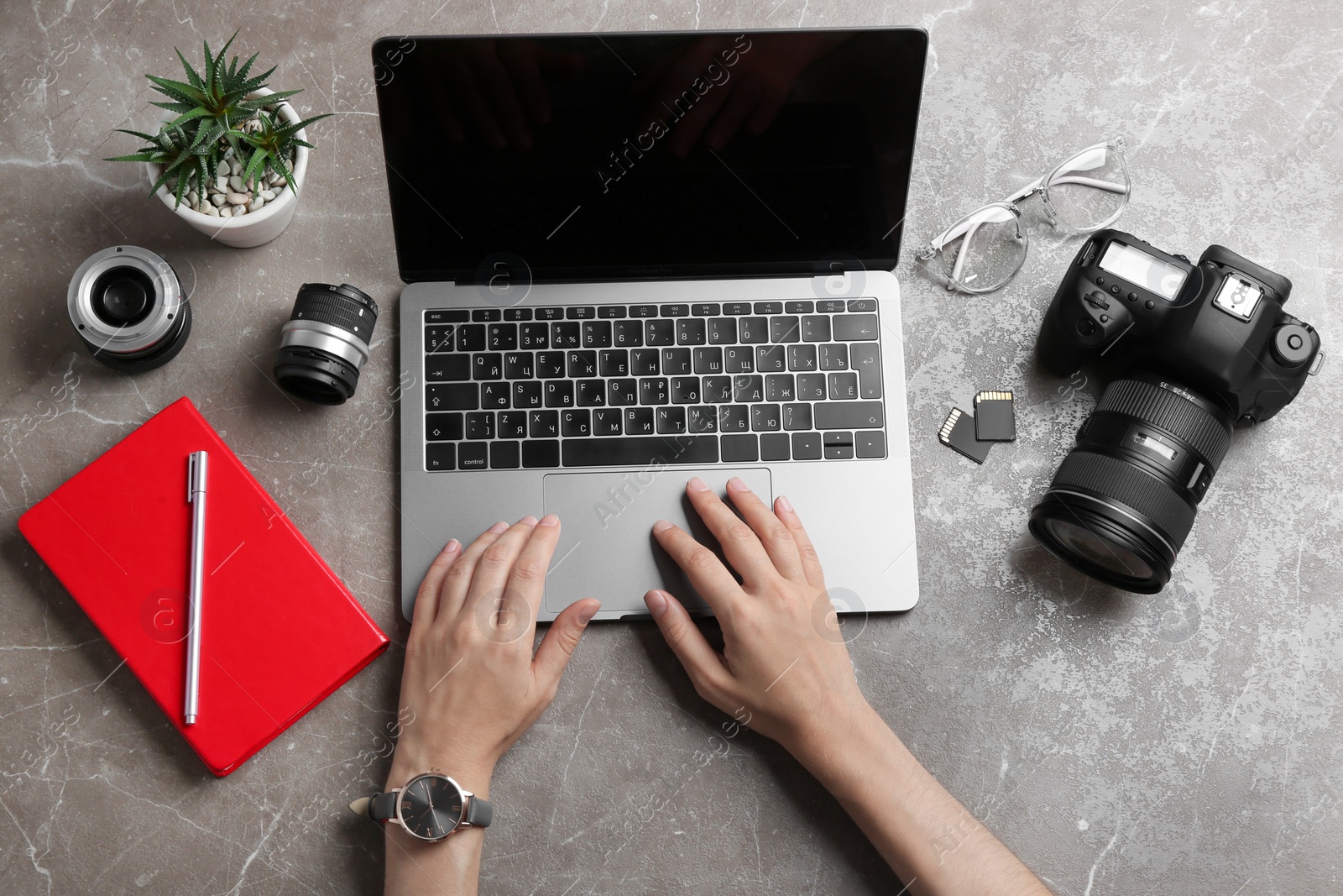 Photo of Female photographer using laptop at table, top view