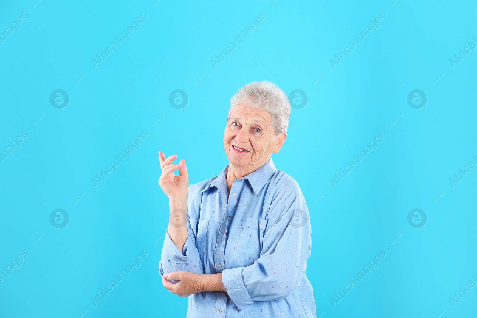 Photo of Portrait of grandmother in stylish clothes on color background