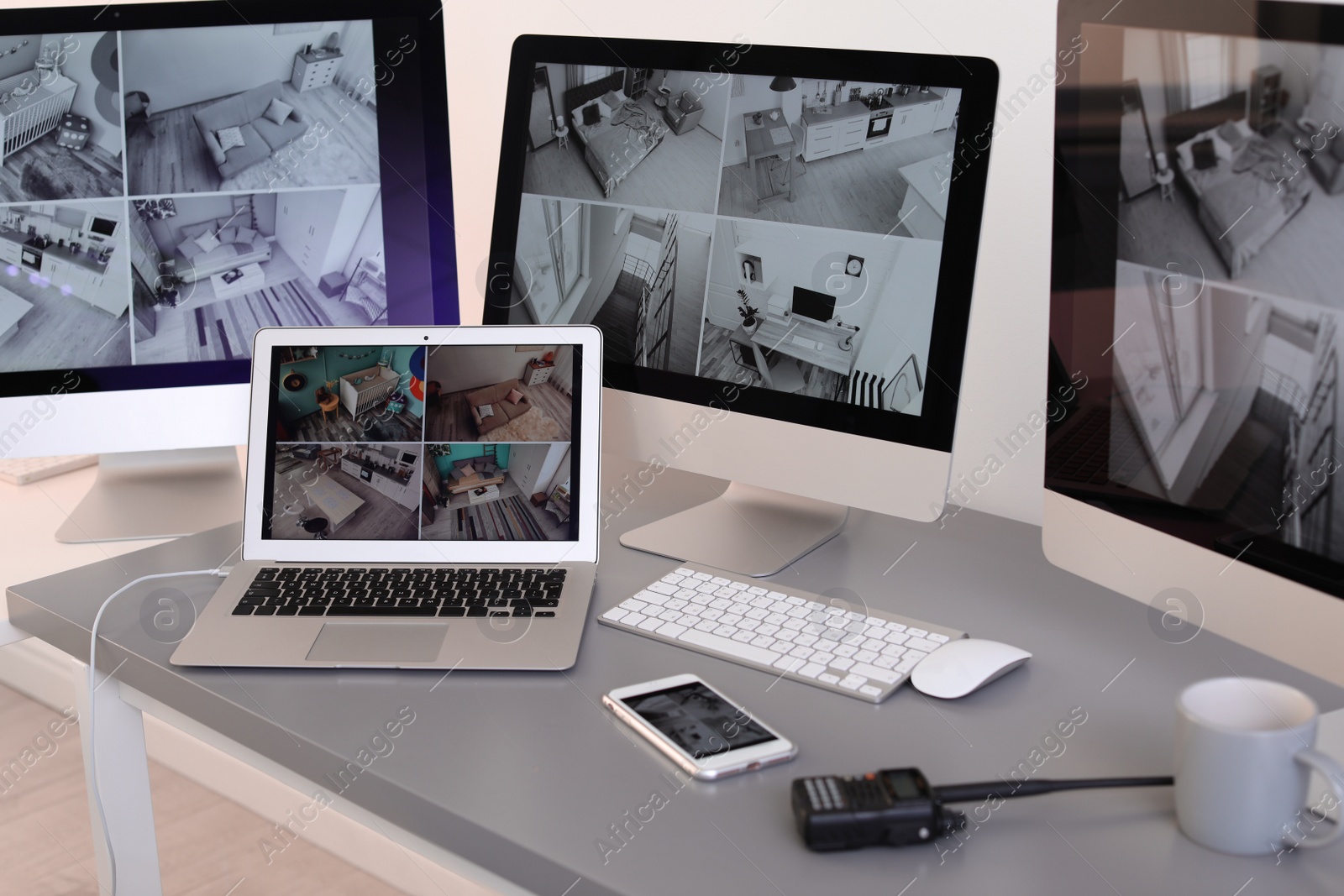 Photo of Modern computers with video broadcasting from security cameras at guard's workplace indoors