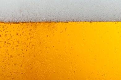 Glass of tasty beer with foam, closeup