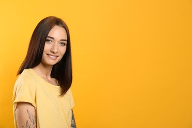 Photo of Portrait of pretty young woman with gorgeous chestnut hair and charming smile on yellow background, space for text