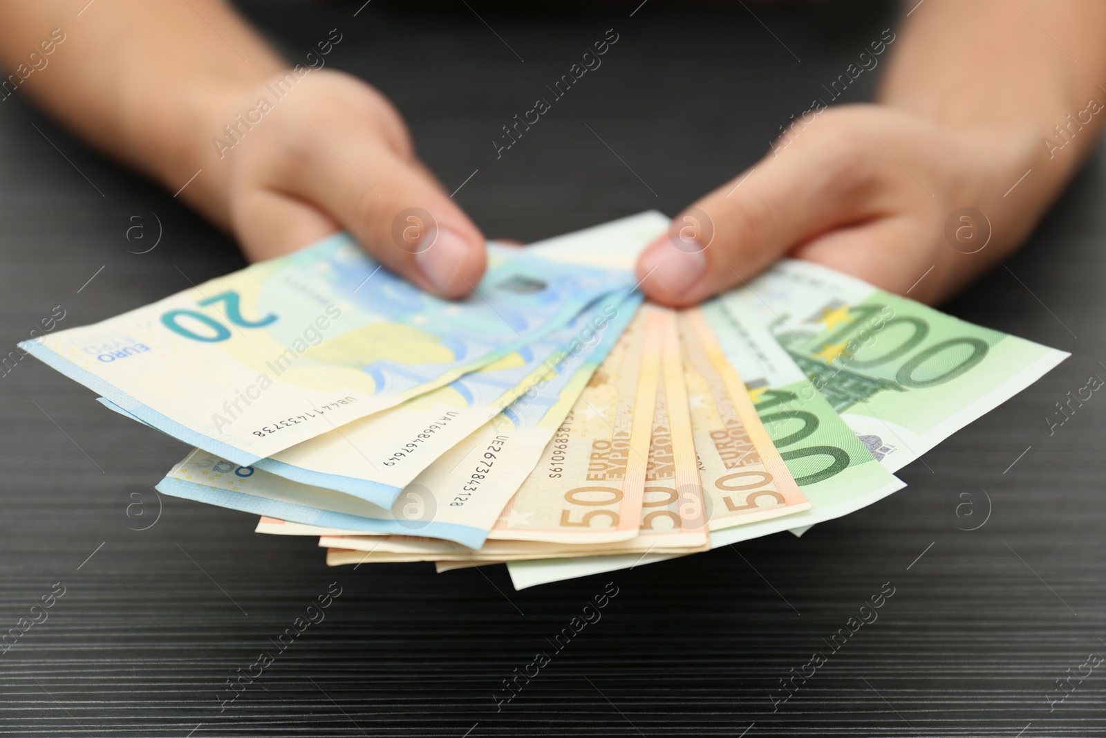 Photo of Man with Euro banknotes at table, closeup