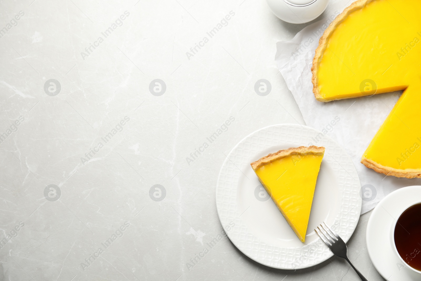 Photo of Delicious homemade lemon pie on light grey marble table, flat lay. Space for text