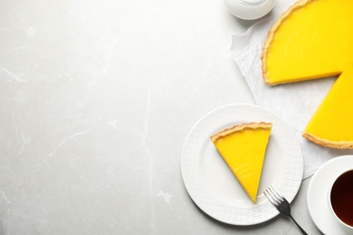 Photo of Delicious homemade lemon pie on light grey marble table, flat lay. Space for text