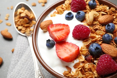 Photo of Tasty homemade granola served on grey table, closeup. Healthy breakfast