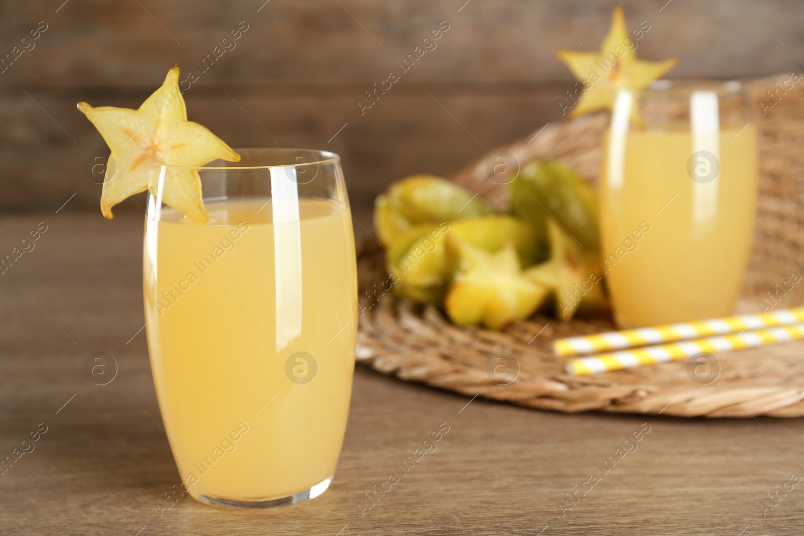 Photo of Delicious carambola juice on wooden table. Space for text