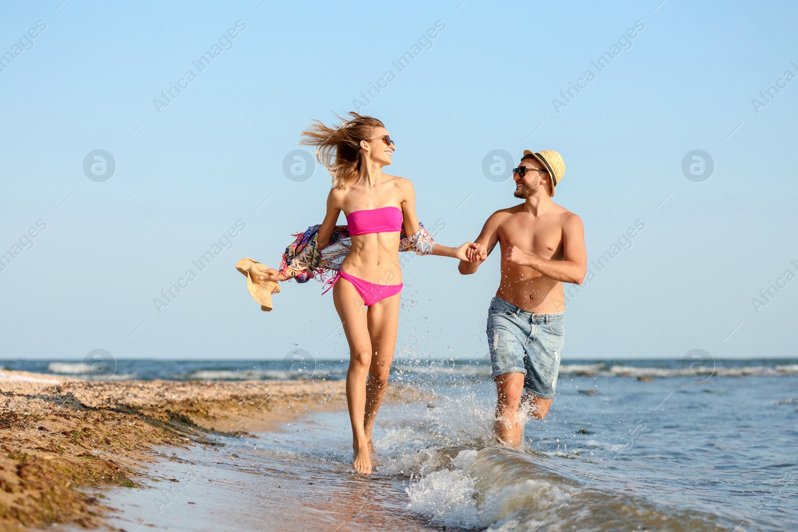 Photo of Young couple spending time together on beach