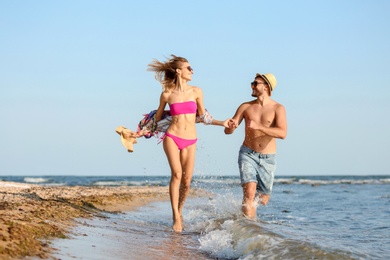 Photo of Young couple spending time together on beach