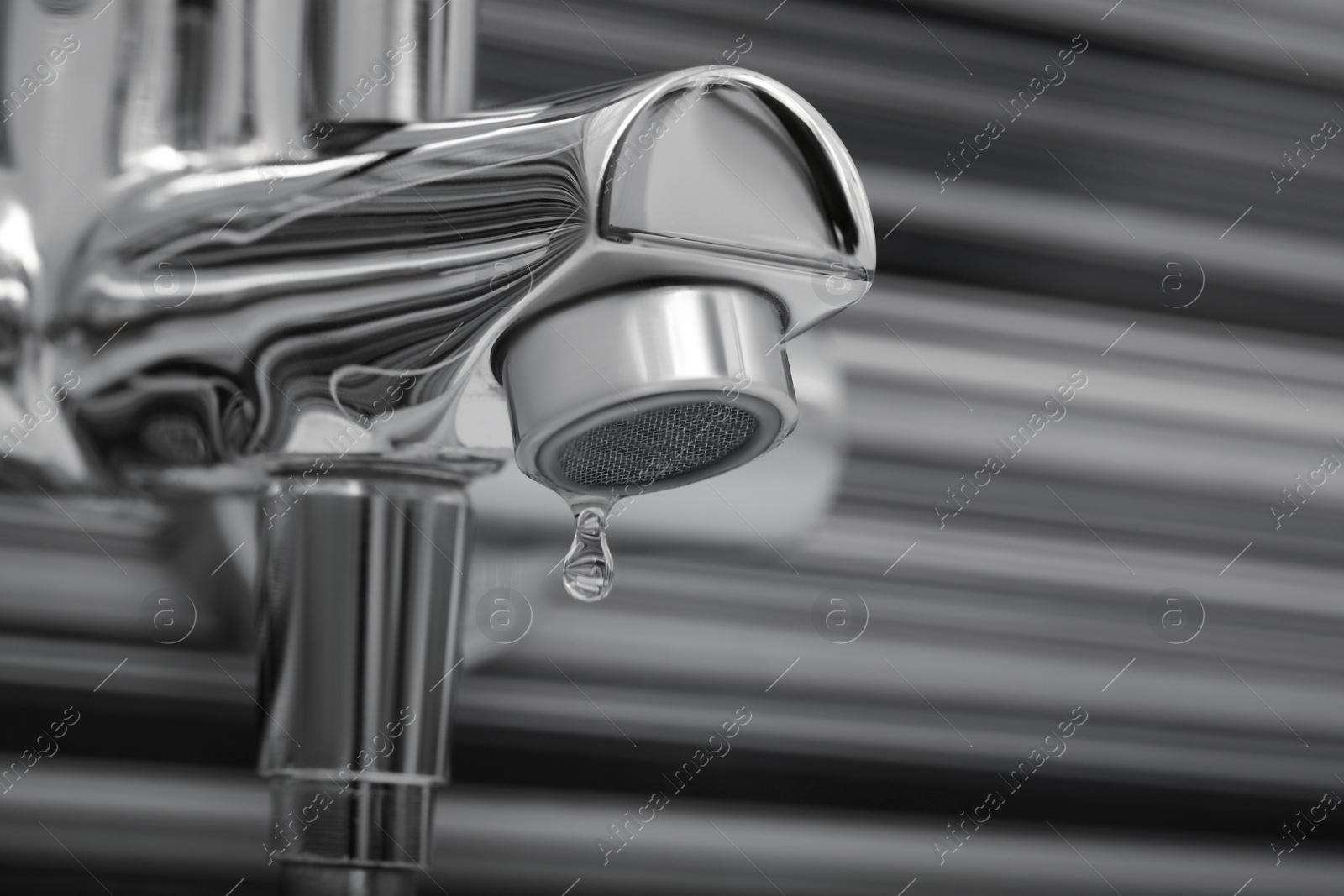 Image of Water drops falling down from tap in bathroom, closeup