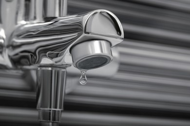 Image of Water drops falling down from tap in bathroom, closeup