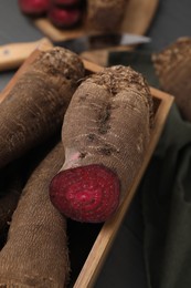 Whole and cut red beets in wooden crate, closeup