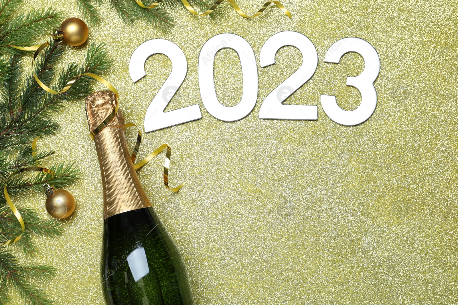 Photo of Happy New Year 2023! Flat lay composition with bottle of sparkling wine on color background, space for text