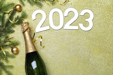 Photo of Happy New Year 2023! Flat lay composition with bottle of sparkling wine on color background, space for text